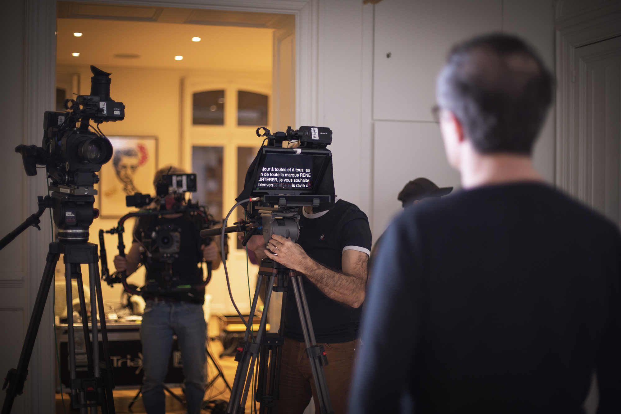 Opérateur de caméra filmant une interview dans un cadre intérieur.